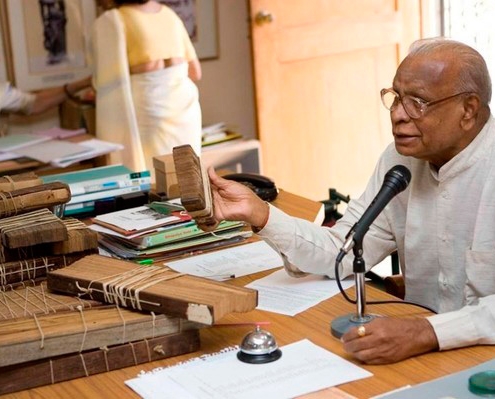 Dr V. Ganapati Sthapati estudando escritos gravados em folhas de palmeira